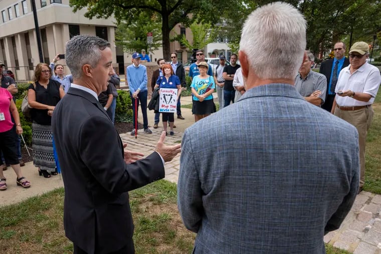 Bob Harvie, chairman of the Bucks County Commissioners, explains his opposition to a proposed $1.1 billion sale of the county's sewer system to Aqua Pennsylvania at a rally outside the Bucks County Courthouse in Doylestown on Wednesday. Aqua later said it was discontinuing talks with the county because of the opposition of elected officials.