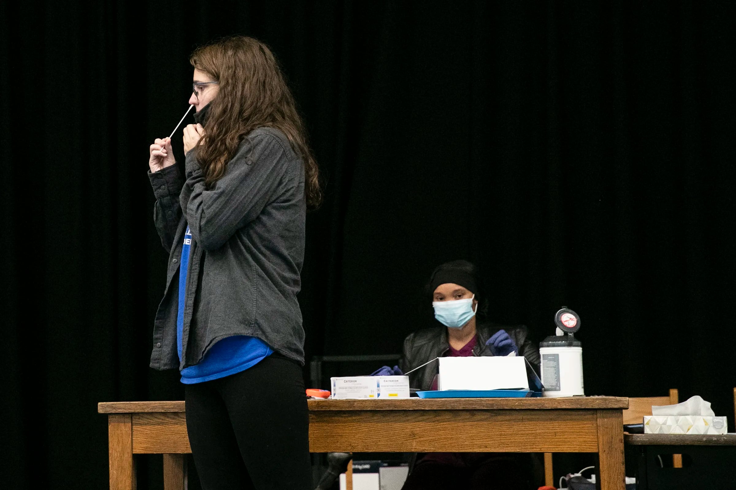 Boys and Girls club staff member Alex Frame swabs her nose during a routine COVID-19 test in the cafeteria at William H. Ziegler Elementary School in October 2021.