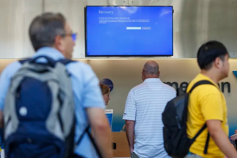 A monitor with a blue screen read, “Recovery, It looks like Windows didn’t load correctly"at the Philadelphia International Airport Friday.