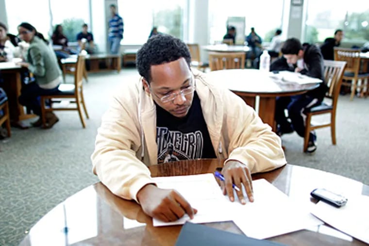 N.J. schools will look to better retain new students like Jamir Morrison, 34, who fills out admissions paperwork at Burlington County College's site in Mount Laurel. (David Swanson / Staff Photographer)