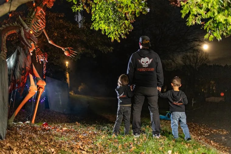 Mike Kane and his two sons Kyle and Mikey wear matching FrightMaps sweatshirts at their home in West Chester, Pa. Mike Kane created the app in 2022 to help people find elaborate holiday displays near them.