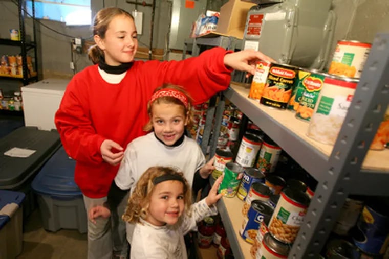 Buss sisters (from back) Anna, Grace, and Abigail stock Bridge of Peace Community Churchâs pantry in Camden. (Charles Fox / Staff Photographer)
