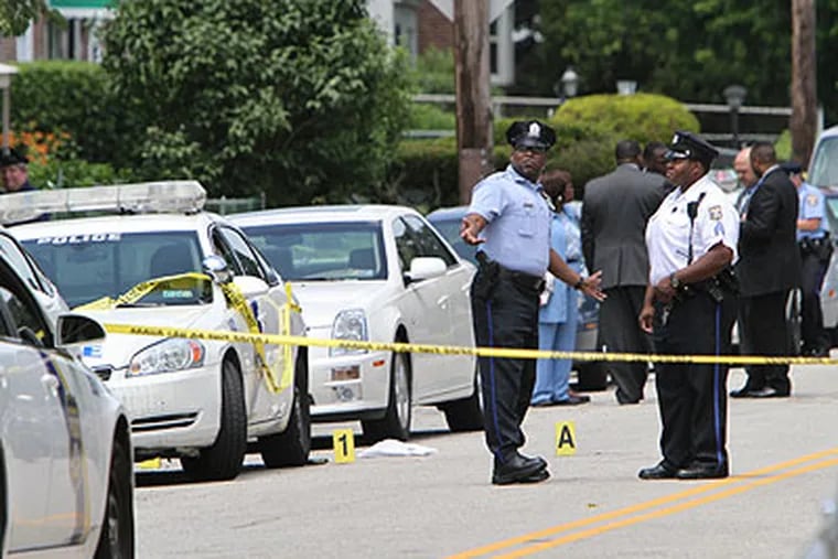 Investigators gather on the 7900 block of Rugby Street in the Stenton section of Philadelphia, on Friday, where police shot and killed SEPTA bus driver Eric Crawley, 39. (Joseph Kaczmarek / For the Inquirer & Daily News)