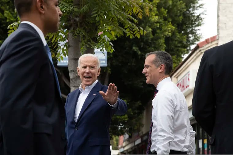 Former vice president and Democratic presidential candidate Joe Biden, left, waves toward members of the media as he and Los Angeles Mayor Eric Garcetti leave King Taco after talking to patrons Wednesday, May 8, 2019, in Los Angeles. (AP Photo/Jae C. Hong)