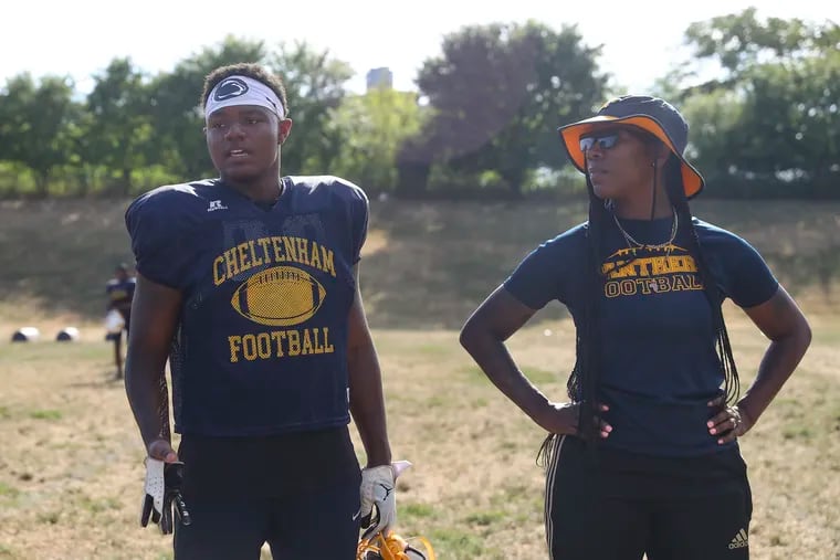 Kion Wright, left, speaks to his teammates while his mother and coach, Qiana “Star” Wright, right, watches during football practice at Cheltenham High School on Wednesday, Aug. 17, 2022. Wright is a top high school football player in the area while his mother, Star, also plays tackle football with the Philadelphia Phantomz.