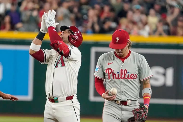 Arizona’s Eugenio Suárez looks skyward after hitting an RBI double in the third inning as Phillies second baseman Bryson Stott looks on.