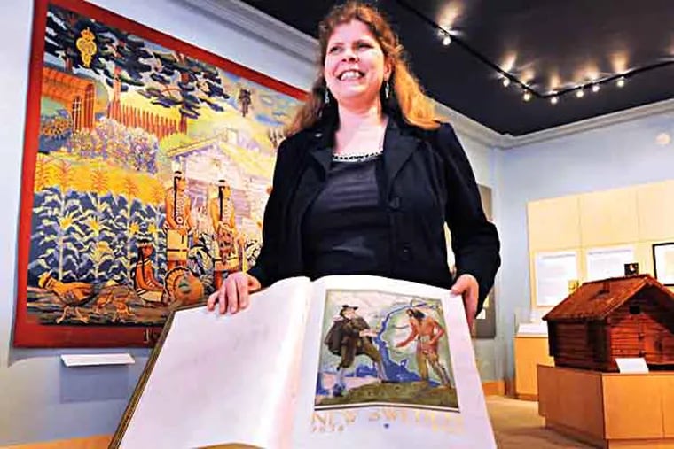 The American-Swedish Museum in South Philly gets itself ready for the King and Queen of Sweden to visit on 5/9/13.  Here, Director Tracey Beck with the historic guest book that has been signed by royals and dignitaries over the years.  ( APRIL SAUL / Staff )