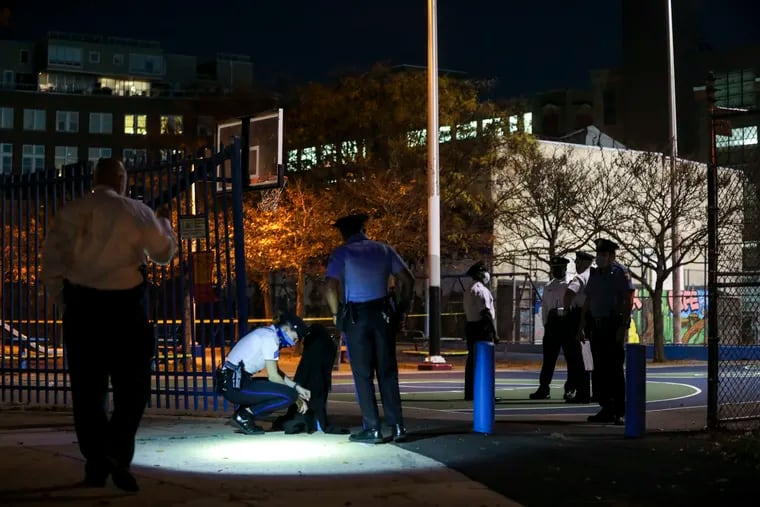 Philadelphia Police investigate a double shooting on the basketball court in the 1200 block of Carpenter Street on Tuesday. A 15-year-old boy was hospitalized in critical condition and a second teen was also wounded.