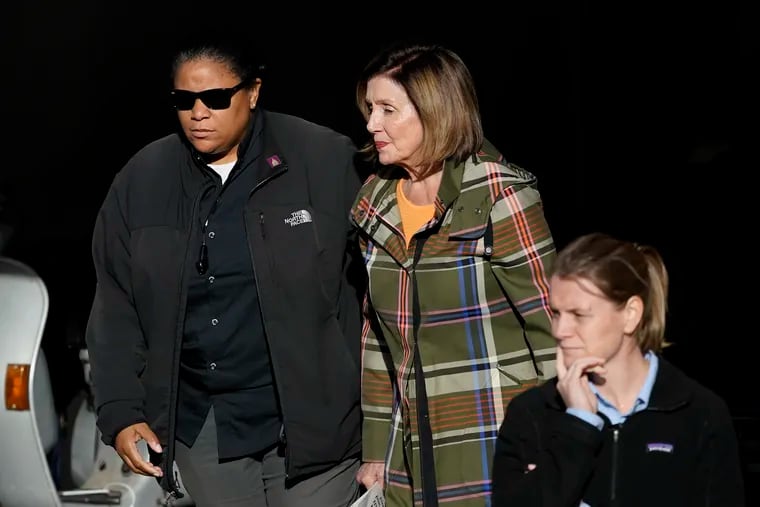 House Speaker Nancy Pelosi, middle, is escorted to a vehicle outside of her and husband Paul Pelosi's home in San Francisco,.