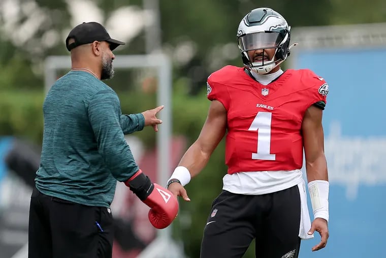 Quarterback Jalen Hurts  talks with running backs coach Jemal Singleton at Eagles training camp.