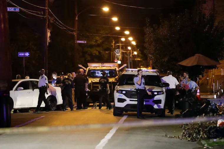 Police officers gather along the 500 block of Dauphin Street in North Philadelphia near where an officer was grazed in the head by a bullet on Monday, August 23, 2021.