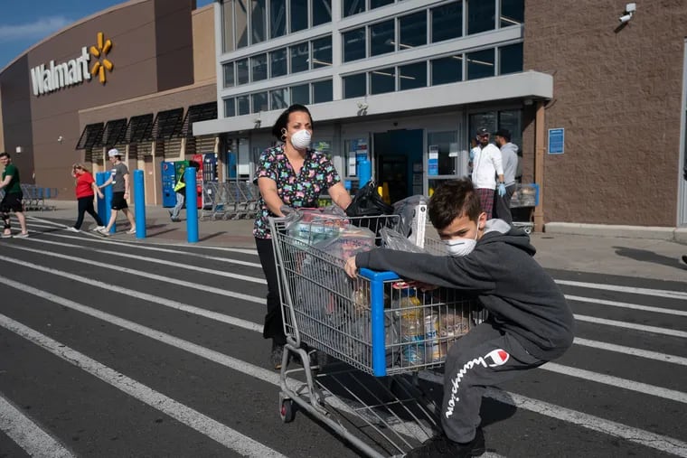 Jessica Torres Terreforte, a certified nursing assistant, and her son Daniel Terreforte, in the parking lot of Walmart at the Philadelphia Mills Shopping Center on March 20, 2020. Ms. Terreforte wears a mask and gloves, and carries hand sanitizer at the hospital where she works and in public to keep from contracting the coronavirus.