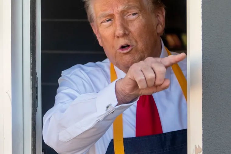 Former President Donald Trump works the drive-thru window at a McDonald’s.