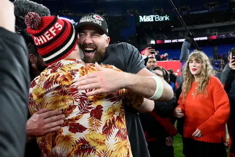 Jason Kelce embraces his brother, Kansas City Chiefs tight end Travis Kelce, after the AFC championship game as Taylor Swift watches.