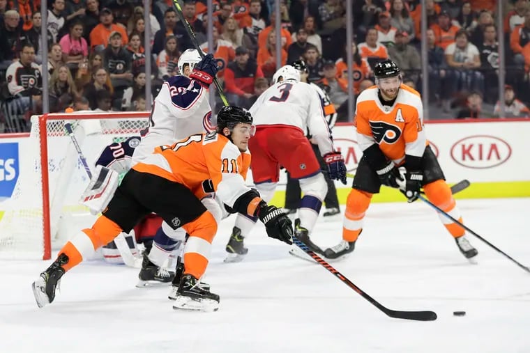 Flyers right winger Travis Konecny reaching for the puck against Columbus Blue Jackets center Riley Nash on Oct. 26. The Flyers rallied for a 7-4 victory.