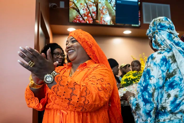 Youma Ba, owner of the West African restaurant Kilimandjaro, joins the festivities of the reopening of her restaurant in a new space at 44th and Chestnut Streets.