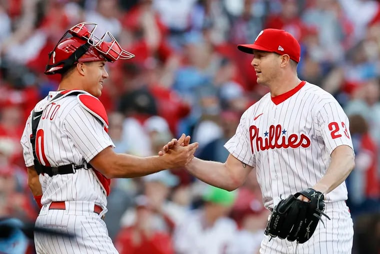 Phillies catcher J.T. Realmuto  and pitcher Corey Knebel celebrate their 9-5 opening day win over the Oakland Athletics on Friday.