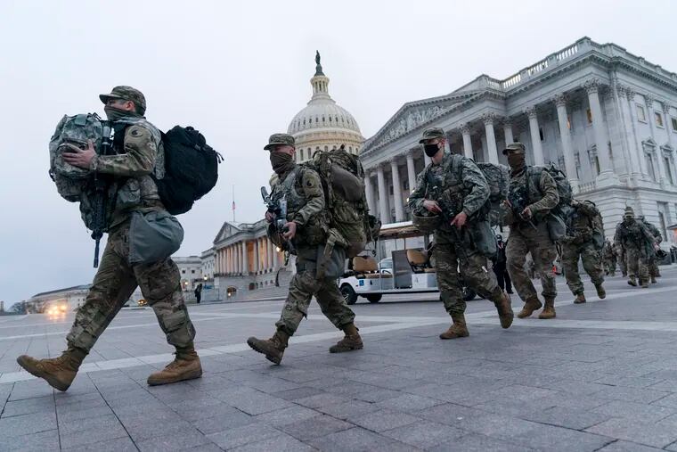 National Guard soldiers walk out of the U.S. Capitol on Saturday in Washington, as security is increased ahead of the inauguration of President-elect Joe Biden and Vice President-elect Kamala Harris.
