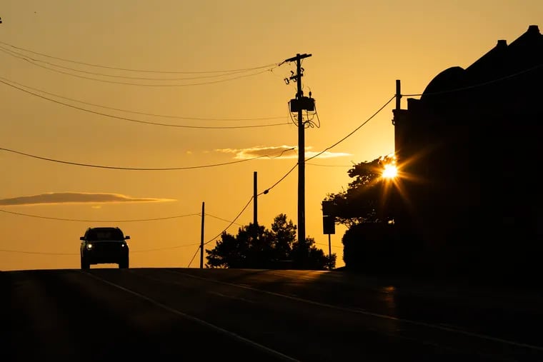 A car makes its way over a hilltop in Lancaster County as the the sun sets on July 21, 2023.