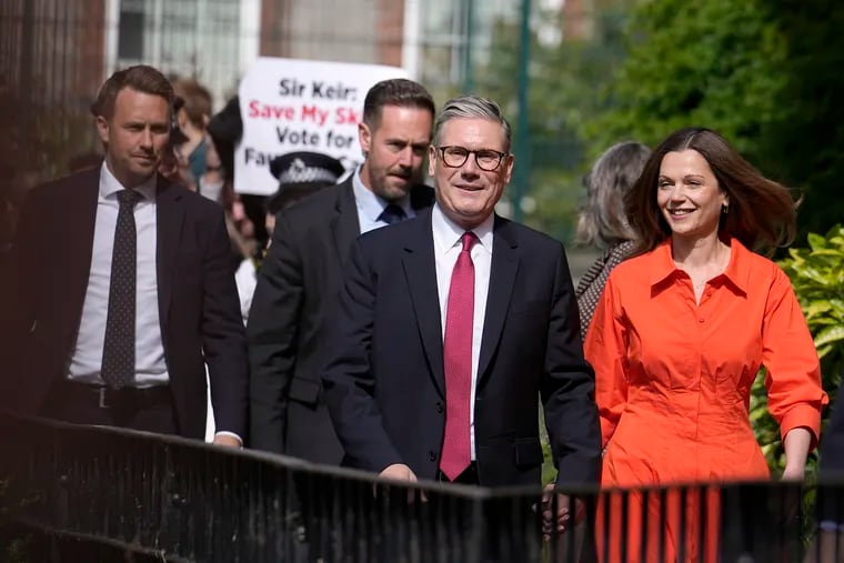 Labour Party leader Keir Starmer (center) and wife Victoria arrive at a polling station to cast their vote in London on Thursday. Starmer is likely to be Britain's next prime minister.