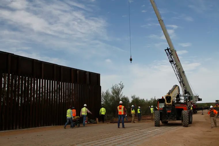 Workers break ground on new border wall construction about 20 miles west of Santa Teresa, New Mexico, Aug. 23, 2019. The wall visible on the left was built in 2018 with money allocated by Congress, while the new construction is funded by money reallocated from Department of Defense funding.