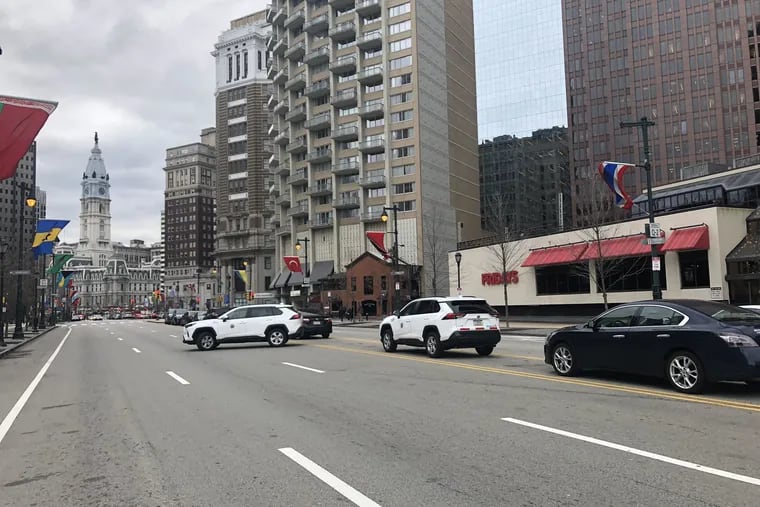 A Philadelphia city car is parked illegally on the median of the Ben Franklin Parkway, while another city car makes an illegal U-turn. The vehicles were in front of Embassy Suites, a popular hotel for tourists and business travelers.