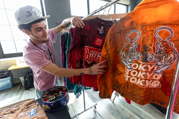 Josh McDonough, 20, of Northeast Philadelphia, at his booth at the Thrift Project displaying some of the custom vibrant clothes he makes. From Northeast Philadelphia, McDonough is registered to vote and interested in politics, but said he’s still torn about whether or not his vote really matters.