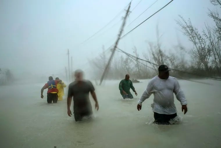 Volunteers wade along a flooded road in Freeport, Grand Bahama, in the aftermath of Hurricane Dorian last September in one of the busier hurricane seasons on record.