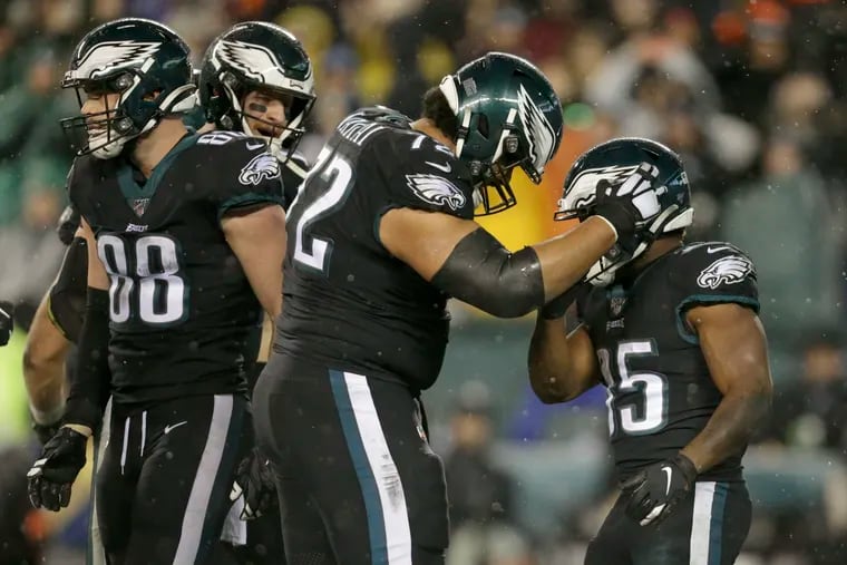 Eagles running back Boston Scott is embraced  by offensive tackle Halapoulivaati Vaitai after Scott scored against the Giants.