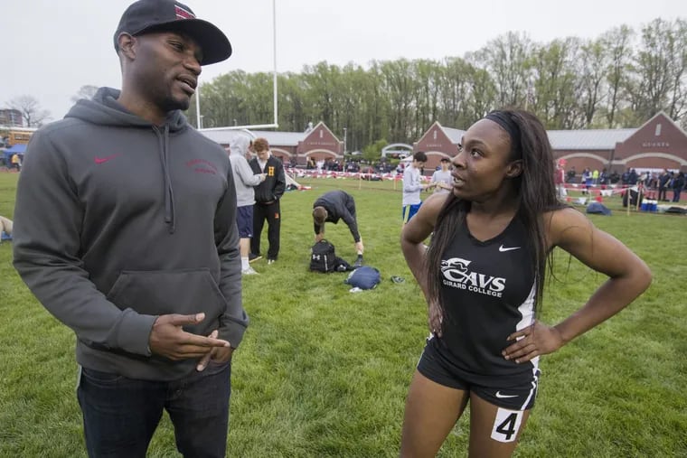 Girard College track Coach Diamond Woolford (left) talks with star sprinter Thelma Davies.