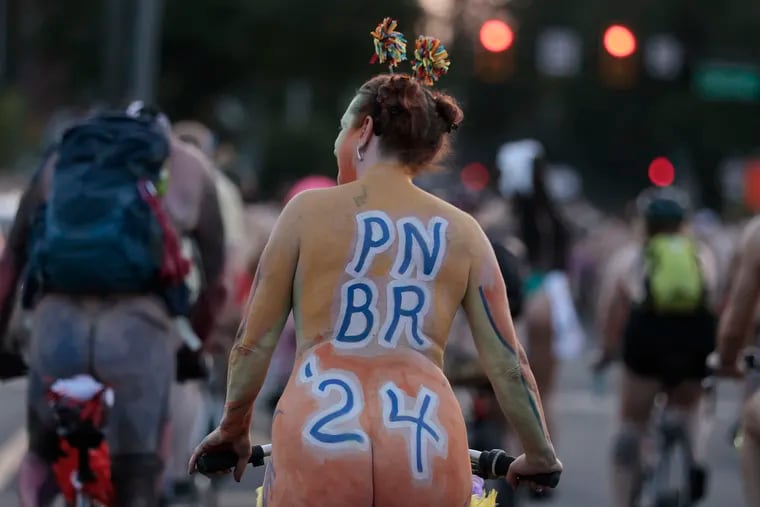 A participant in the Philly Naked Bike Ride 2024 crosses the Spring Garden Bridge in Philadelphia on Saturday, August 24, 2024.