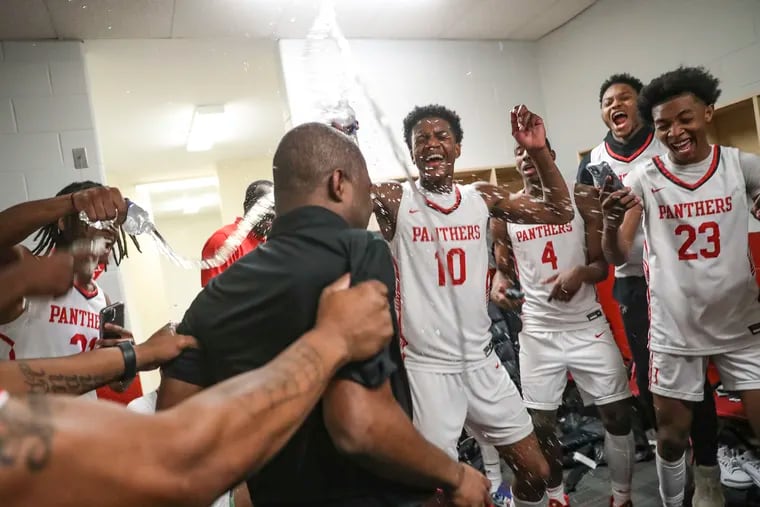 Imhotep players douse their head coach Andre Noble in water in the locker room following their Philadelphia Public League championship win over West Philly.