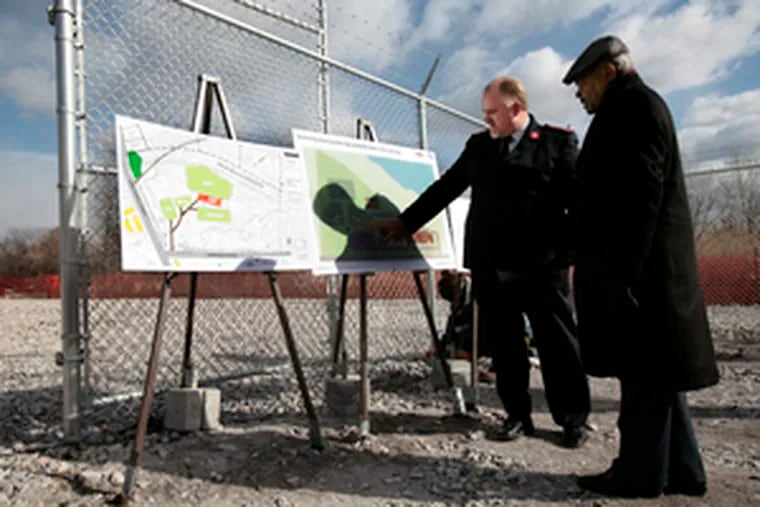 Maj. Paul Cain (left), of the Salvation Army, and Theodore Z. Davis, the city&#0039;s state-appointed chief operating officer, examine plans for a community center on the landfill site.