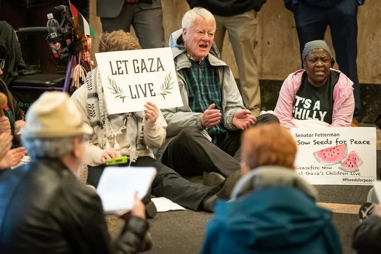 George Lakey, center, an 86-year-old West Philly resident and global leader of nonviolent civil disobedience, shown here at Senator Fetterman's office on 200 Chestnut St. in Philadelphia, urging the senator to reconsider his position on Israel in Gaza, on Thursday, April 11, 2024.