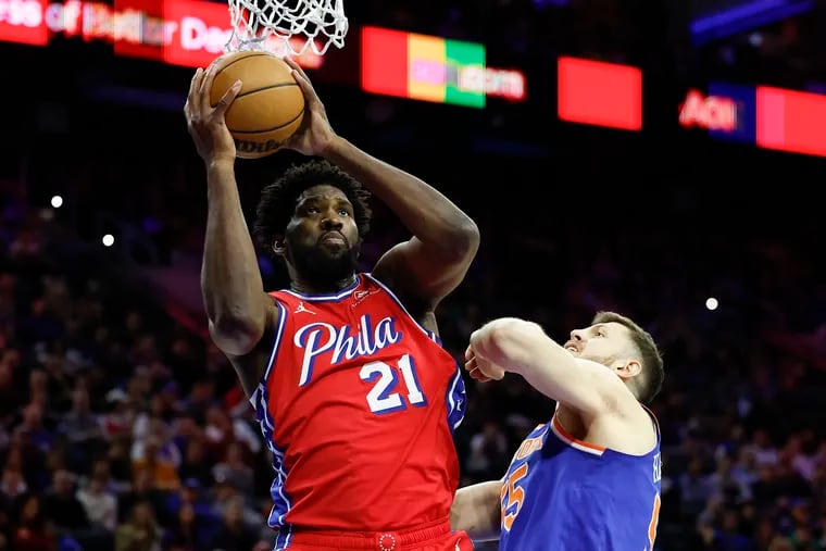 Sixers center Joel Embiid grabs the basketball past Knicks center Isaiah Hartenstein in the first quarter.