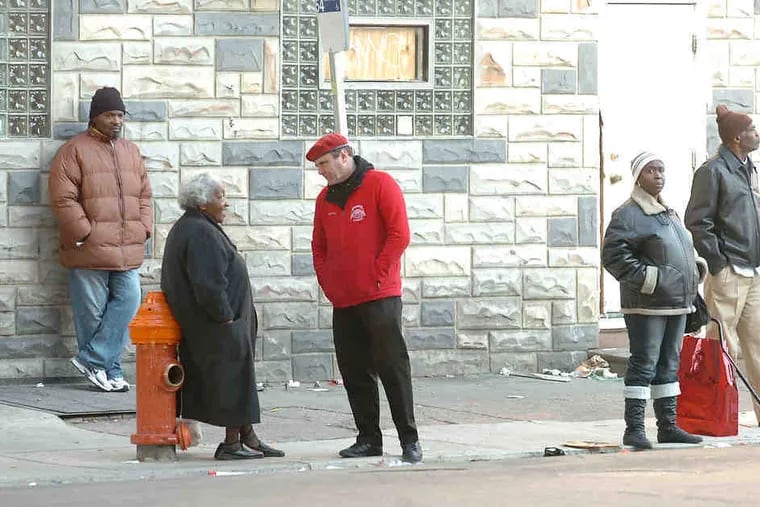 Guardian Angels' Curtis Sliwa (center) talks with Pat Thompson, waiting for a bus at Kensington Avenue and Somerset Street.
