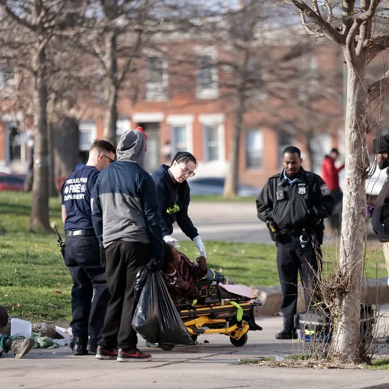 Philadelphia police and emergency workers render aid to a person who possibly overdosed in McPherson Square in March.