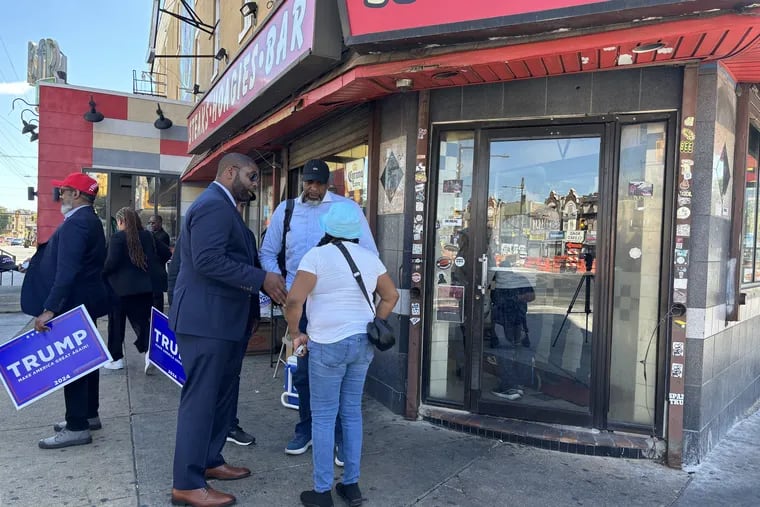 U.S. Rep. Byron Donalds, (R, Fl.) and former Detroit Mayor Kwame Kilpatrick speak with a Philadelphian named Sheila who was passing by a Black Voters for Trump event outside of Max's Steaks on Germantown Avenue Tuesday afternoon.