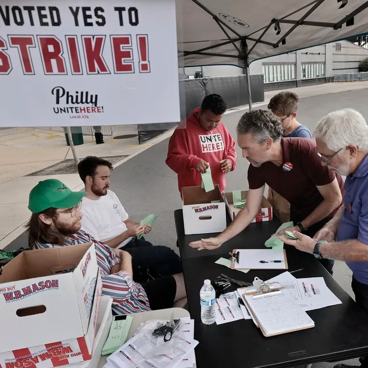 Unite Here organizer Ryan Nissim-Sabat (second from right) and union member John Dezio (far right) count the strike authorization ballots cast by Aramark workers at Lincoln Financial Field Friday before the watch party for the season opener between the Eagles and the Green Bay Packers, being played in Brazil. Union officials said 84% of those who voted approved going on strike if and when Unite Here Local 274 calls for it as contract negotiations continue. Strike authorization votes have also passed at Citizens Bank Park and Wells Fargo Center.