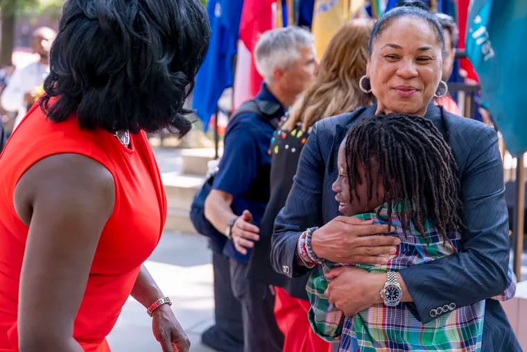 Mayor Cherelle L. Parker, left, gave the first-ever "One Philly Award" to WNBA coach Dawn Staley, right. After the ceremony, Staley gave Parker's son, Langston, a hug.