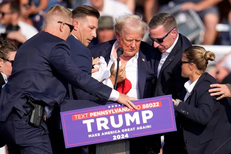 Republican presidential candidate former President Donald Trump is helped off the stage at a campaign event in Butler, Pa., on Saturday.