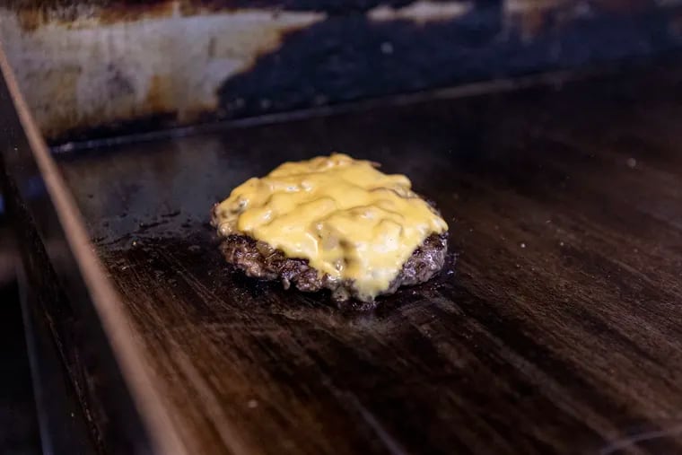 A cheeseburger being made at Spot Gourmet Burgers in Philadelphia.