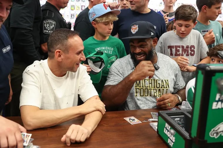 Michael Rubin and Brandon Graham pull trading cards at Wheelhouse Cards in Wayne as part of Topps' Hobby Rip Night event.