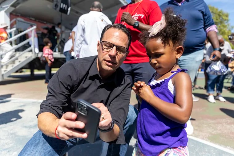 Attorney General Josh Shapiro shows a photo of his daughter to Gianna Wilkerson, 4, of North Philadelphia.