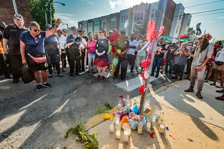 Philadelphia Police Department 12th District and community members stop for a prayer at Chester Avenue and Fraizer Street during an anti-violence prayer walk in the wake of the Kingsessing mass shooting.