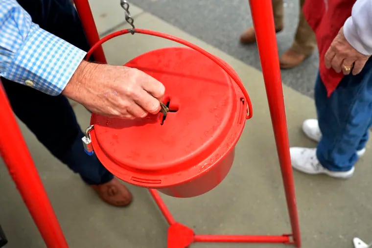 Money gets dropped into the kettle during the Annual Salvation Army Red Kettle drive in a 2018 file photo.