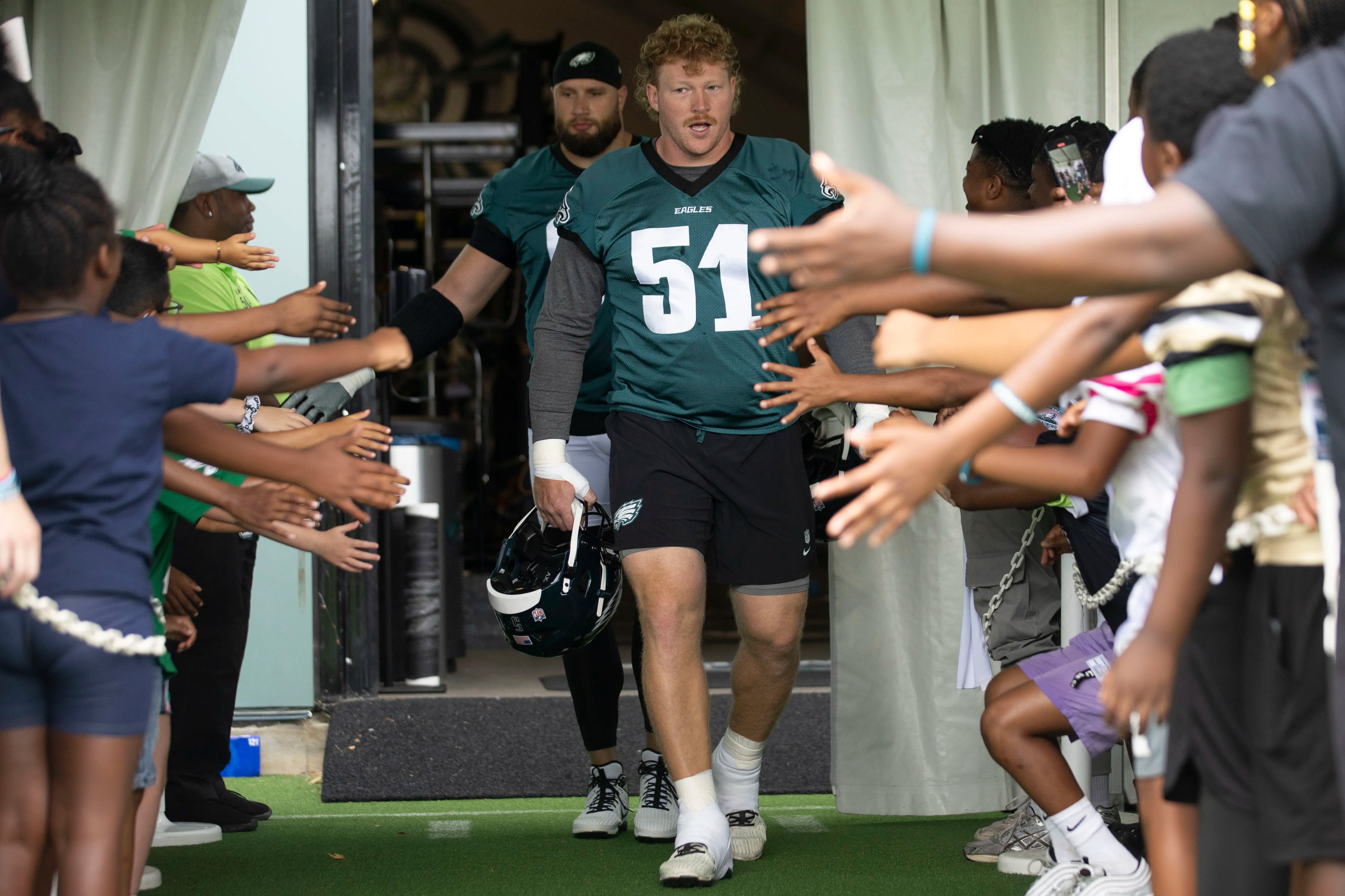 Eagles center Cam Jurgens (51) and offensive tackle Lane Johnson take the field during the first day of training camp on July 24.