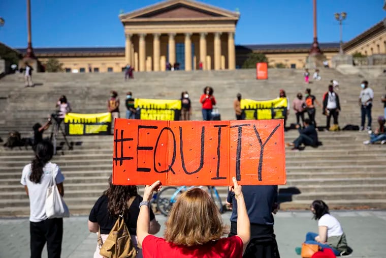 Debra O'Connor of Philadelphia, holds a sign reading “#Equity” during a rally in honor of Breonna Taylor at the Art Museum steps on Oct. 4.