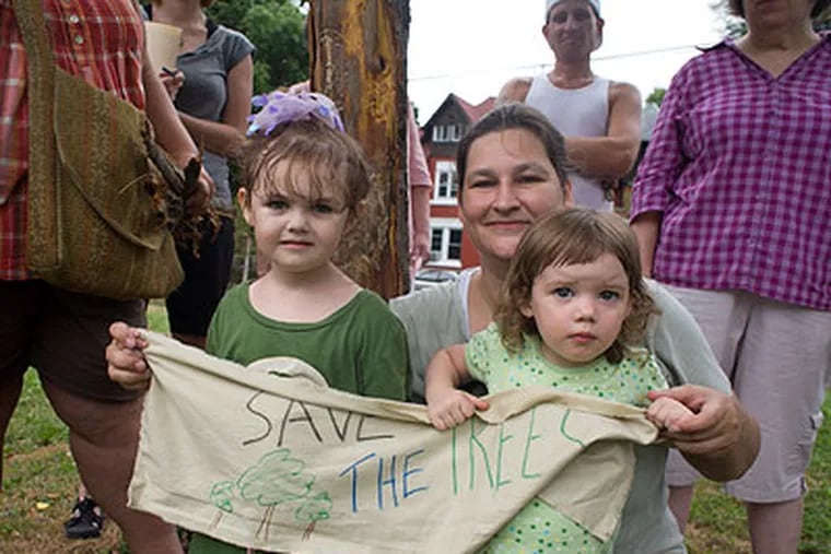 Lisa Handy, center, with her daughter Lina, 3 1/2, left and friend Fern Jenson-Moore, 2, right, hold a sign that reads "Save the Trees." (Ed Hille / Staff Photographer)