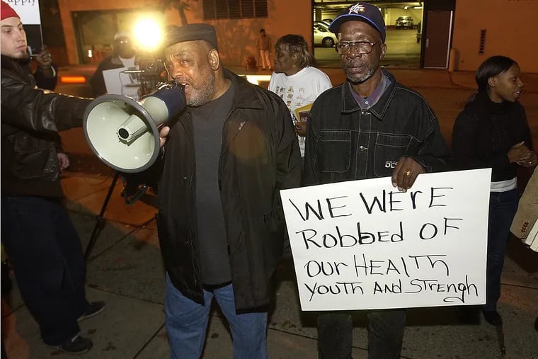 In this file photo, Leodus Jones, left, and Warren Summers, both formerly incarcerated Holmesburg Prison, protest outside the College of Physicians of Phila.,  which was giving an award to a University of Pennsylvania dermatologist who conducted experiments at Holmesburg.